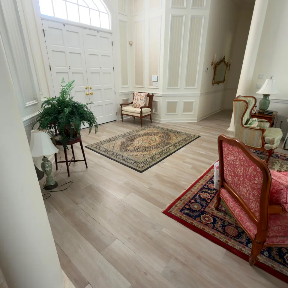Entry foyer with wood-look tile flooring flowing between rooms