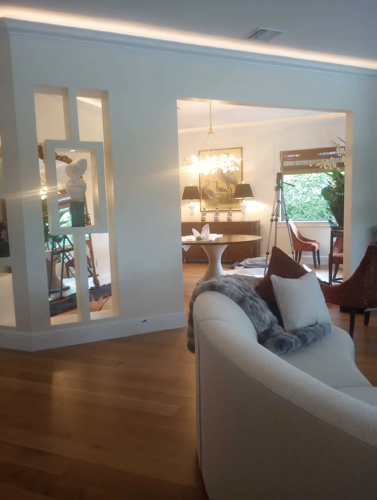 Formal living and dining rooms with light natural plank flooring and a decorative room divider