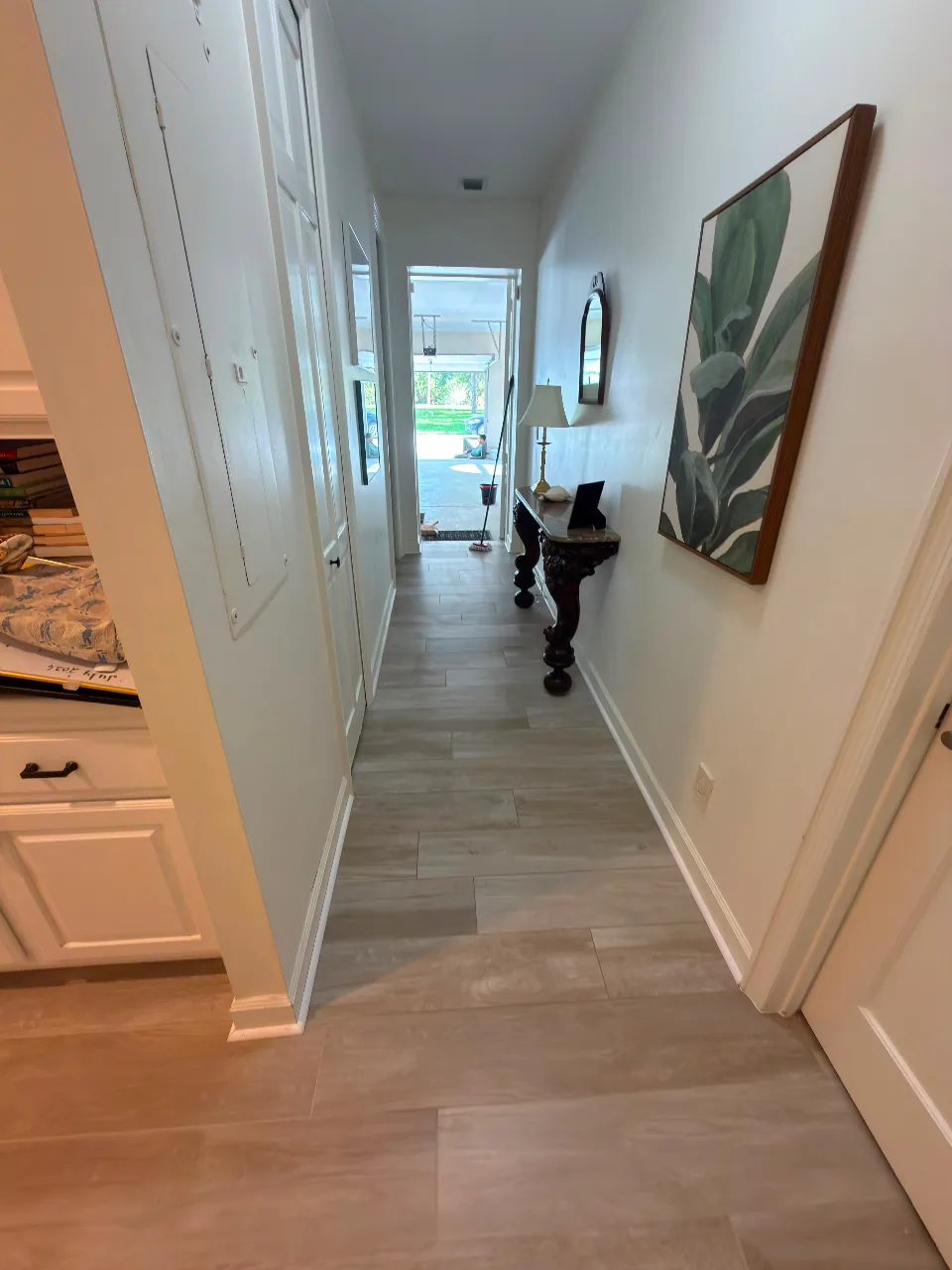 Hallway with wood-look tile in a staggered layout and clean baseboard transitions