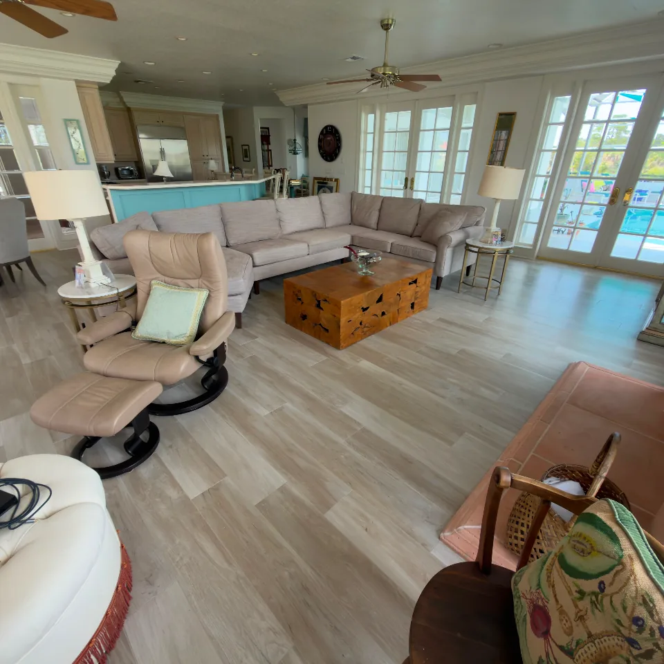 Finished open living room with light wood-look tile flooring